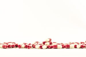(Symbolbild) Rote und weißé Pillen auf weißem Untergrund